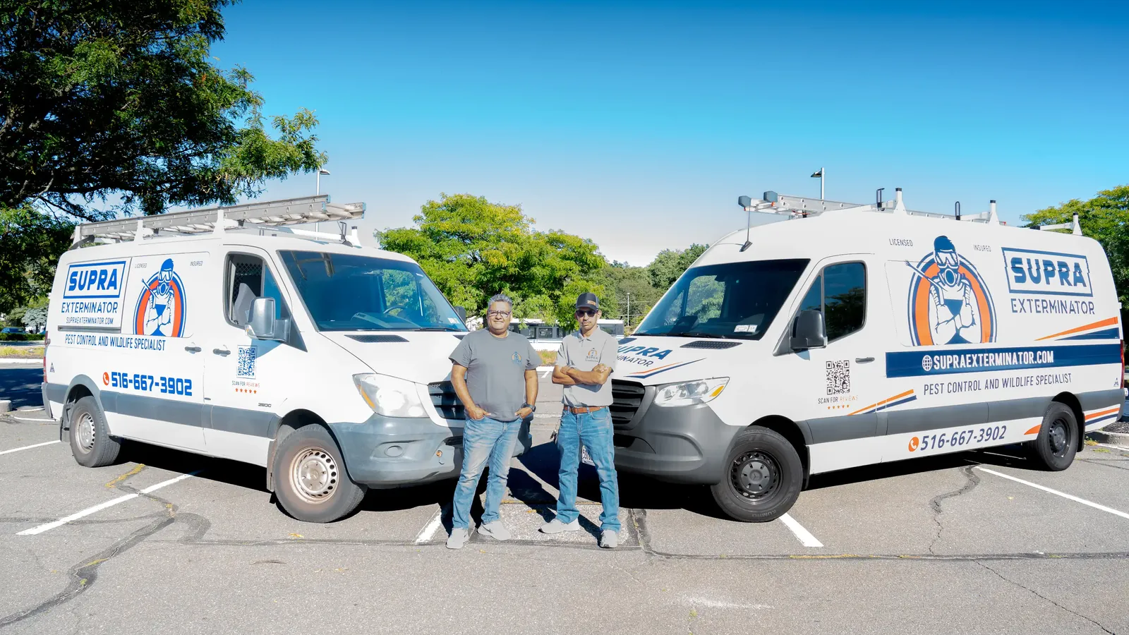 The two Supra Exterminator owners standing in front of their marked pest control and wildlife service vans